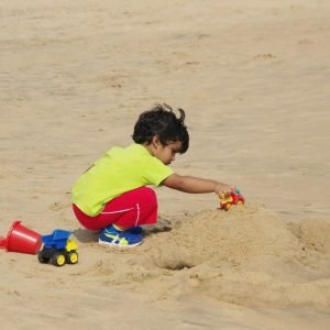 Little boy playing in the sand on a family beach vacation