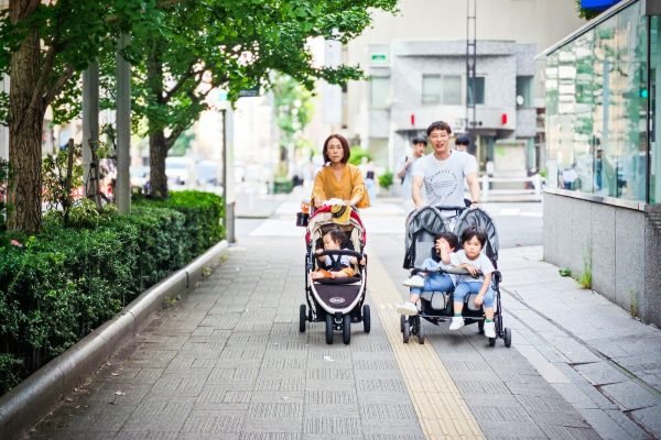Parents pushing children in a stroller on vacation