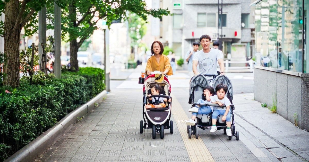 Parents pushing children in a stroller on vacation