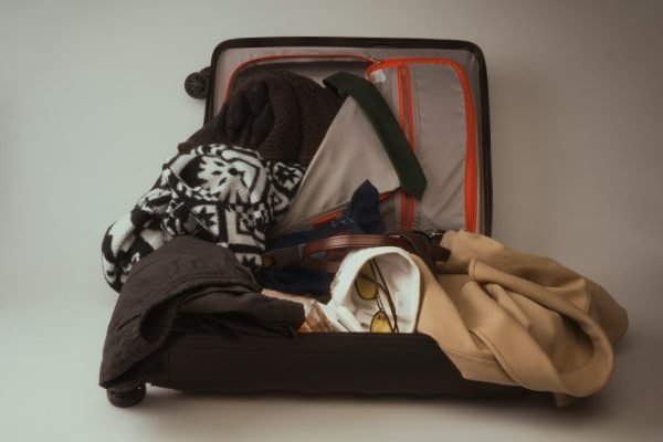 Open suitcase packed for a family vacation