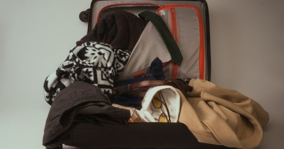 Open suitcase packed for a family vacation
