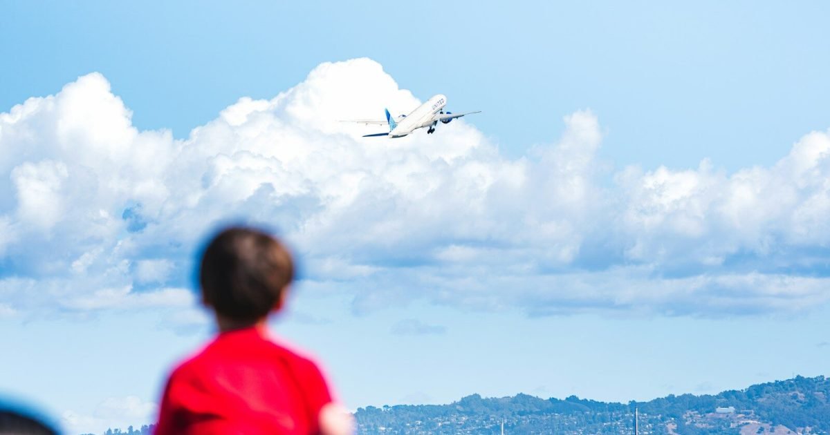 Child watching an airplane take off from the airport