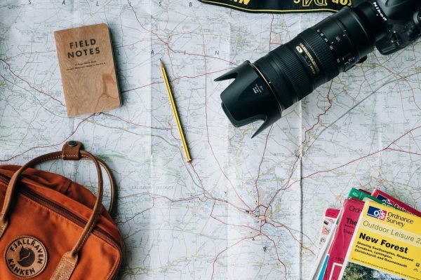 Planning a family trip with a map, camera and notebook