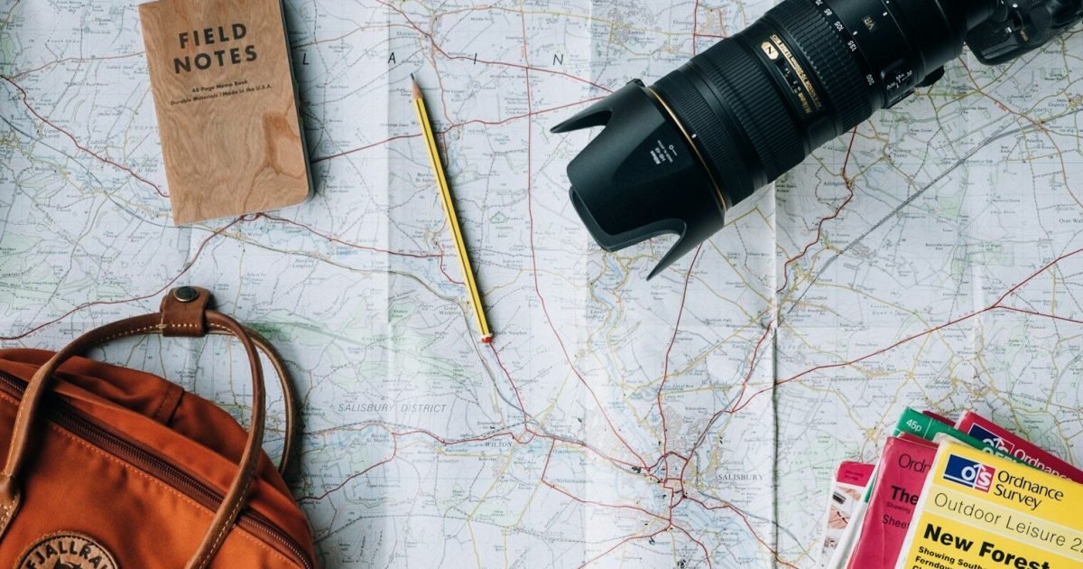 Planning a family trip with a map, camera and notebook